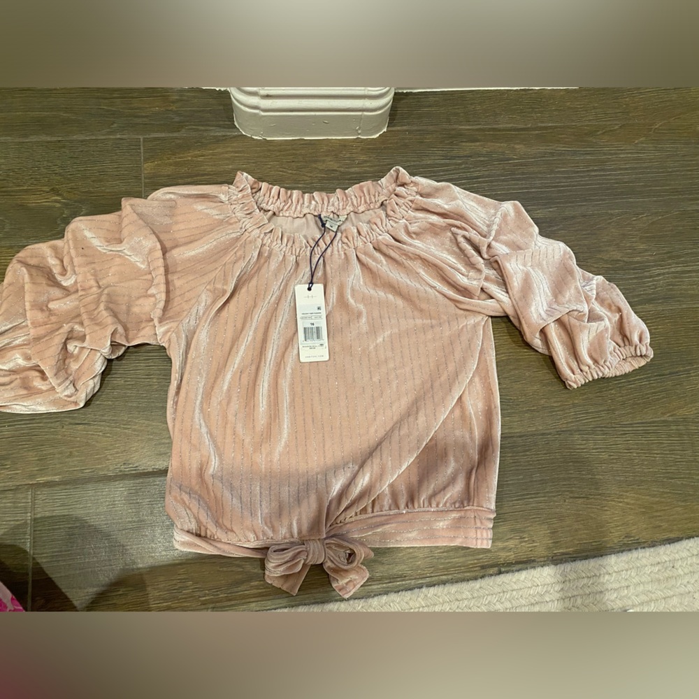 light pink velvet with silver accents, ruched arms, bow on the bottom.